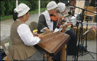 Musicians playing dulcimer and fiddle in colonial dress